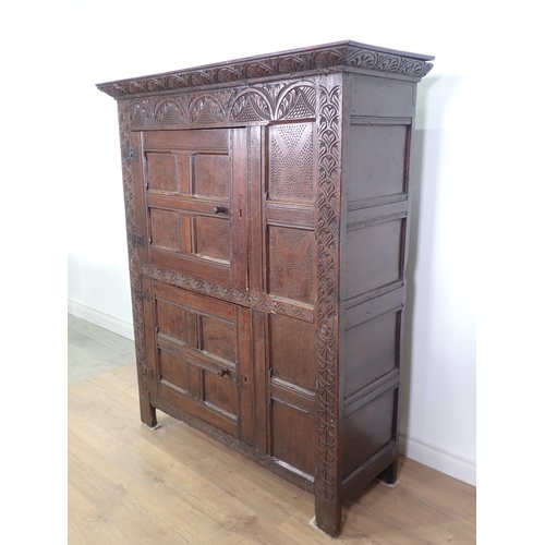 453 - A 17th Century and later oak ventilated Food Cupboard with carved cornice and frieze, two panelled c... 