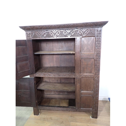 453 - A 17th Century and later oak ventilated Food Cupboard with carved cornice and frieze, two panelled c... 