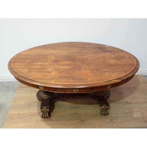 455 - A Regency rosewood Centre Table with moulded oval top, raised on cheval base of two painted and gild... 