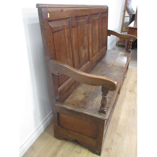 458 - An antique oak Settle with fielded panelled back, shaped arms and replacement panels to the base, 5f... 