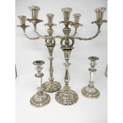 50 - A pair of Sheffield plated two-branch, three-light Candelabrum and a pair of plated Candlesticks on ... 