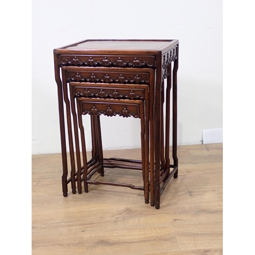 528 - A nest of four Chinese hardwood Tables with carved friezes, raised on shaped turned supports and str... 