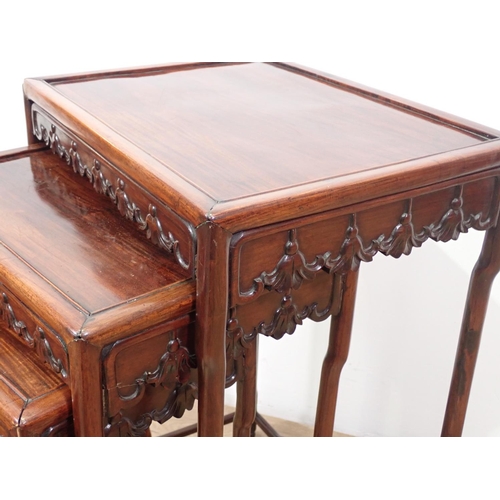 528 - A nest of four Chinese hardwood Tables with carved friezes, raised on shaped turned supports and str... 