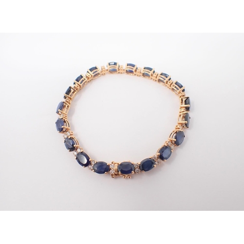 84 - A Sapphire and Diamond line Bracelet claw-set nineteen oval-cut sapphires, total sapphire weight 16.... 