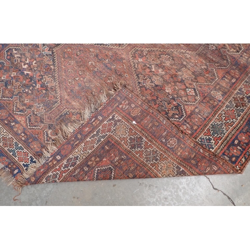 377A - An old bordered Kazak type Rug with triple lozenge having latchhooks, 6ft 9in x 9ft 4in, worn