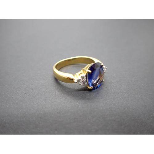 159 - A Sapphire and Diamond Ring claw-set oval-cut sapphire 3.08cts between trios of brilliant-cut diamon... 