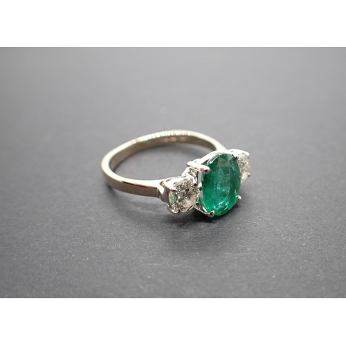 166 - An Emerald and Diamond three stone Ring claw-set oval-cut emerald, 1.71cts, between two brilliant-cu... 