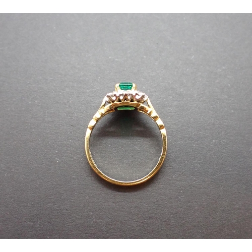 184 - An Emerald and Diamond Cluster Ring corner claw-set step-cut emerald within a frame of brilliant-cut... 