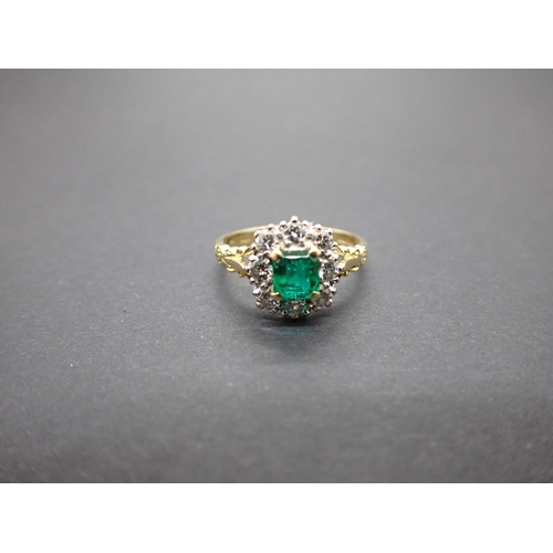 184 - An Emerald and Diamond Cluster Ring corner claw-set step-cut emerald within a frame of brilliant-cut... 