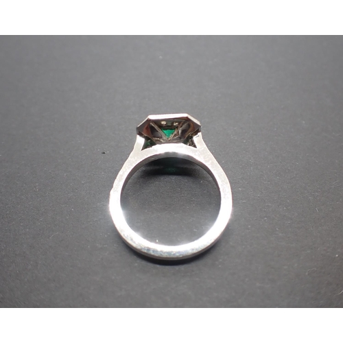 188 - An Art Deco style Emerald and Diamond Cluster Ring set step-cut emerald, 1.27cts, within a frame of ... 