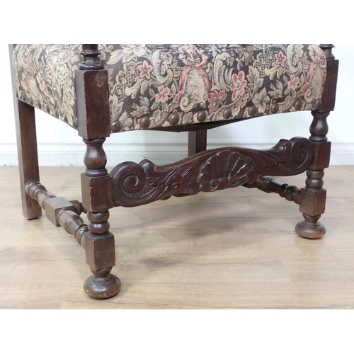 73 - A needlework upholstered oak framed Armchair with leafage carved scroll arms on square cut and turne... 