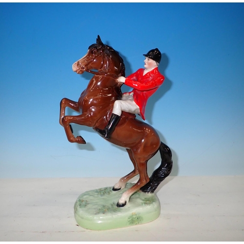 562 - A Beswick Huntsman in hunting pink jacket on rearing bay horse, impressed 868, Tail A/F