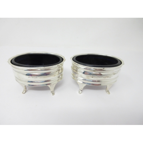 100 - Pair of Edward VII silver oval Salts with shaped rims, blue glass liners on reeded feet, Sheffield 1... 