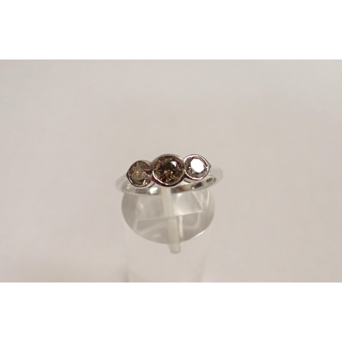 168 - A Diamond three stone Ring rubover-set champagne brilliant-cut stone between two lighter stones in 1... 