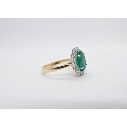 195 - An Emerald and Diamond Cluster Ring claw-set oval-cut emerald, 2.78cts, within a frame of fourteen b... 