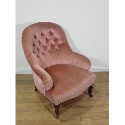 20 - A 19th Century pink upholstered button back Armchair on turned mahogany supports and brass casters