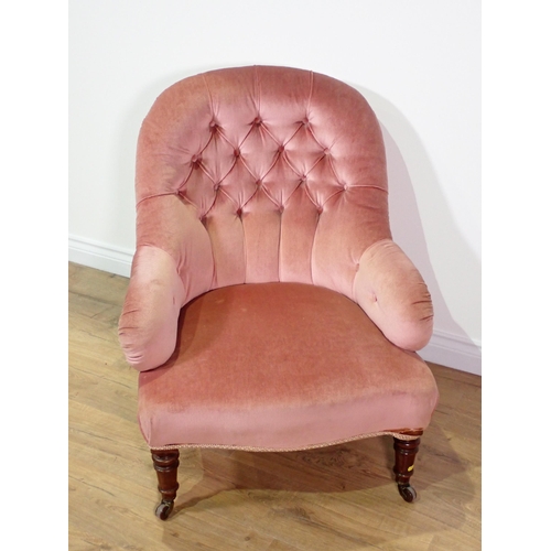 20 - A 19th Century pink upholstered button back Armchair on turned mahogany supports and brass casters