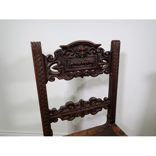 39 - A Spanish style carved oak Chair with scroll and griffin mask back rails and tooled leather seat on ... 