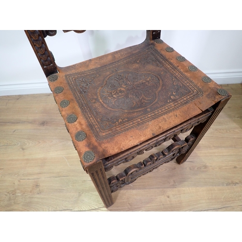 39 - A Spanish style carved oak Chair with scroll and griffin mask back rails and tooled leather seat on ... 