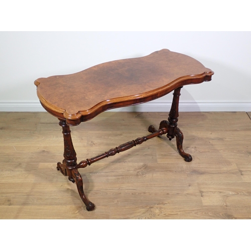 437 - A Victorian burr walnut veneered Centre Table with shaped top on cheval base on carved scrolled supp... 