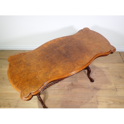 437 - A Victorian burr walnut veneered Centre Table with shaped top on cheval base on carved scrolled supp... 