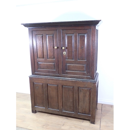 581 - An 18th Century and later panelled oak Linen Press fitted pair of cupboard doors above four panel ba... 