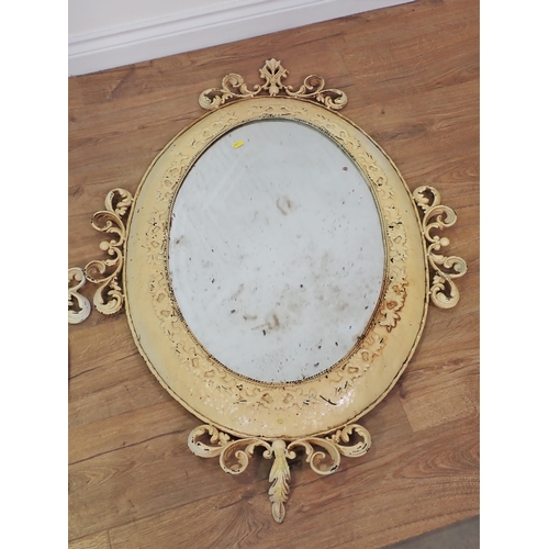 584 - A pair of cream painted oval Wall Mirrors with scroll and leafage decoration 3ft 6in W x 2ft 6in H