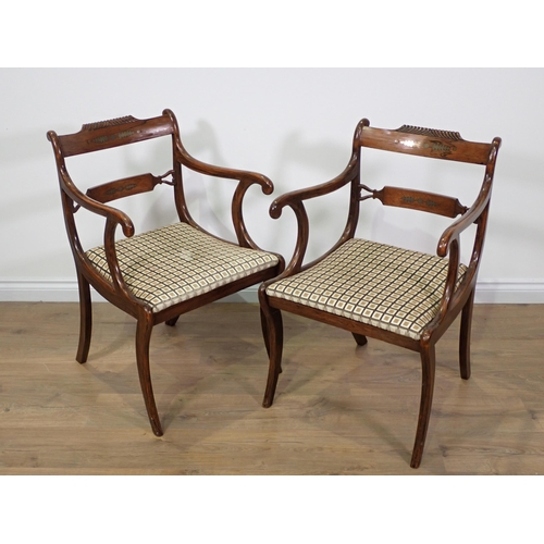 682 - A pair of Regency rosewood and brass inlaid Elbow Chairs on sabre supports