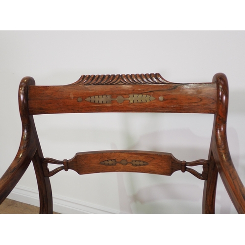 682 - A pair of Regency rosewood and brass inlaid Elbow Chairs on sabre supports