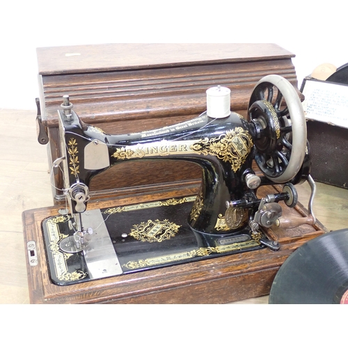 693 - An oak cased Singer Sewing Machine and two cases of Records