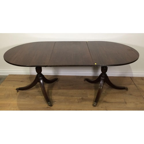 700 - A reproduction mahogany veneered twin pedestal Dining Table with spare leaf