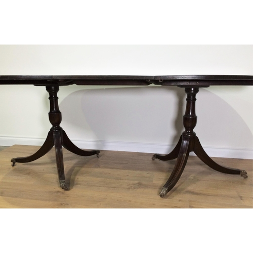 700 - A reproduction mahogany veneered twin pedestal Dining Table with spare leaf