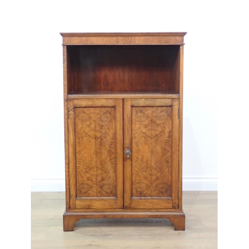 706 - A figured mahogany veneered Bookcase fitted pair of cupboard doors beneath shelf mounted upon bracke... 