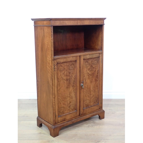 706 - A figured mahogany veneered Bookcase fitted pair of cupboard doors beneath shelf mounted upon bracke... 