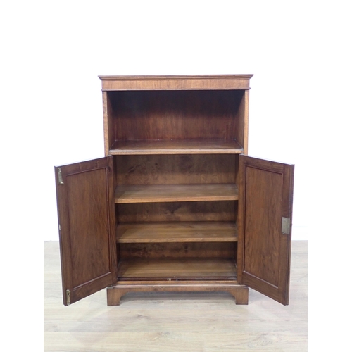 706 - A figured mahogany veneered Bookcase fitted pair of cupboard doors beneath shelf mounted upon bracke... 