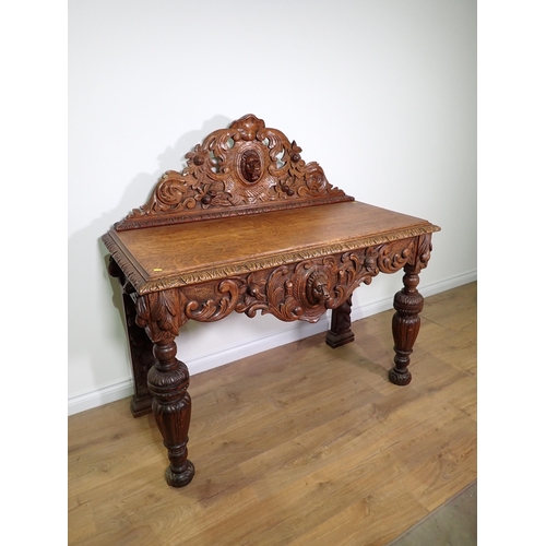 711 - A Victorian carved oak Serving Table with raised back and shaped apron with lion mask and acanthus l... 