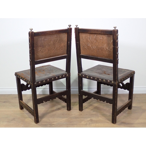 714 - A pair of oak Chairs with tooled leather back and carved front rail on square cut supports