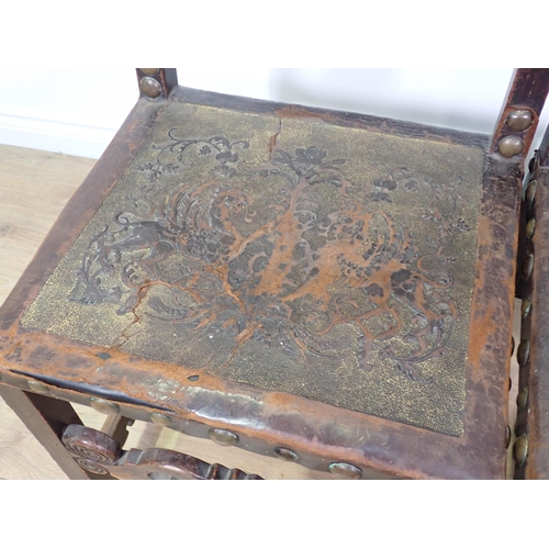 714 - A pair of oak Chairs with tooled leather back and carved front rail on square cut supports