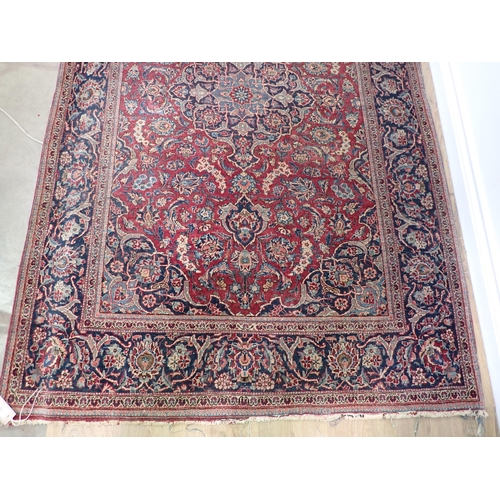 730 - A red ground Rug with floral design within dark blue border 6ft 8in L x 4ft 4in W