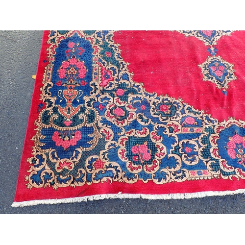 788 - A large Chinese red ground Carpet with blue central floral lozenge and broad borders 13ft L x 10ft W... 