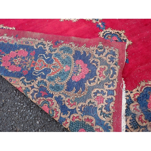 788 - A large Chinese red ground Carpet with blue central floral lozenge and broad borders 13ft L x 10ft W... 