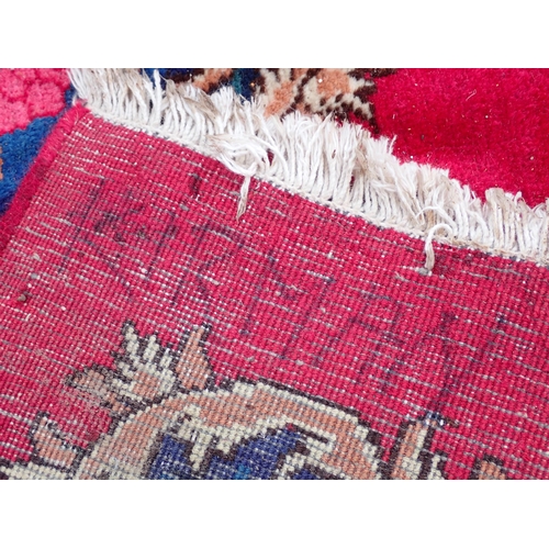 788 - A large Chinese red ground Carpet with blue central floral lozenge and broad borders 13ft L x 10ft W... 