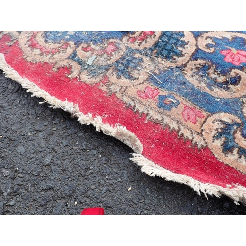 788 - A large Chinese red ground Carpet with blue central floral lozenge and broad borders 13ft L x 10ft W... 