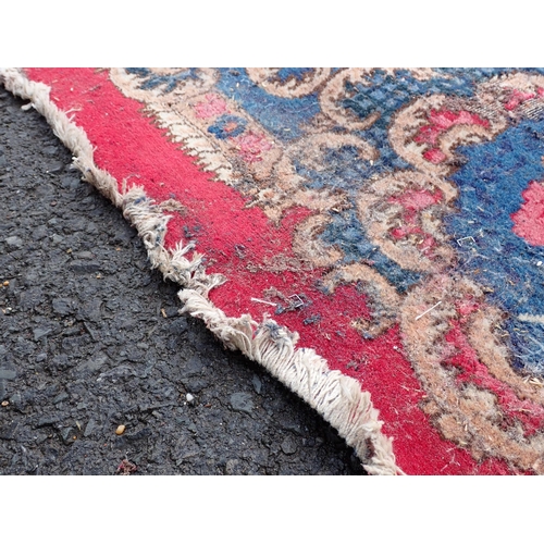 788 - A large Chinese red ground Carpet with blue central floral lozenge and broad borders 13ft L x 10ft W... 