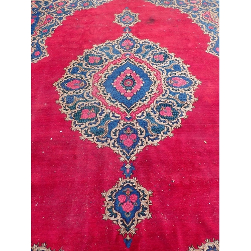 788 - A large Chinese red ground Carpet with blue central floral lozenge and broad borders 13ft L x 10ft W... 