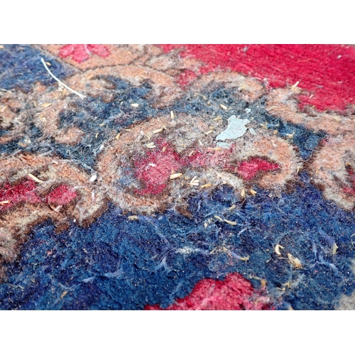 788 - A large Chinese red ground Carpet with blue central floral lozenge and broad borders 13ft L x 10ft W... 