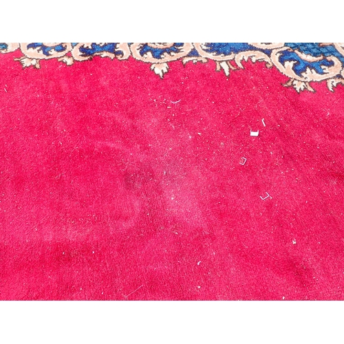 788 - A large Chinese red ground Carpet with blue central floral lozenge and broad borders 13ft L x 10ft W... 