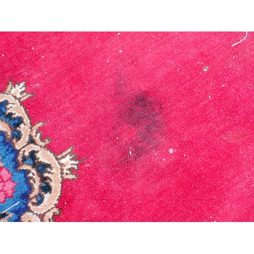 788 - A large Chinese red ground Carpet with blue central floral lozenge and broad borders 13ft L x 10ft W... 