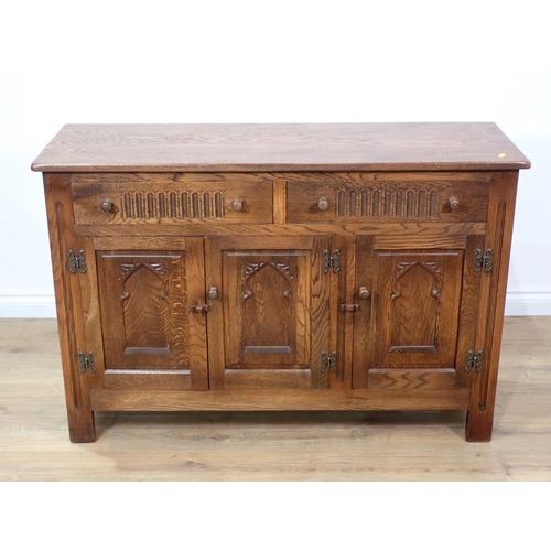 100 - An oak Sideboard fitted two frieze drawers above three arch carved cupboard doors 4ft W x 2ft 8in H