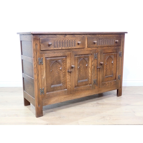 100 - An oak Sideboard fitted two frieze drawers above three arch carved cupboard doors 4ft W x 2ft 8in H